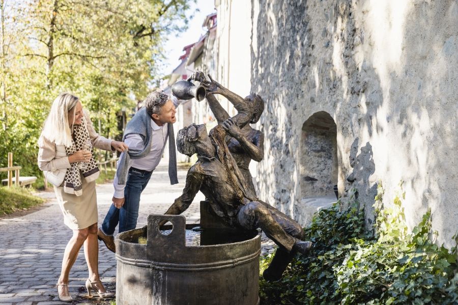 Ein Paar steht am "Kopfwäschebrunnen", der außerhalb der Stadtmauern der Stadt Wangen im Allgäu steht