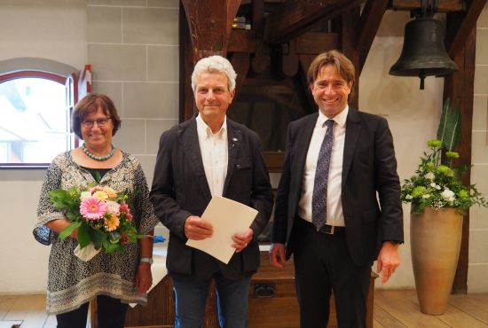 Christl Rasch mit Blumen, Norbert Rasch mit der Landesehrennadel und Oberbürgermeister Michael Lang 
