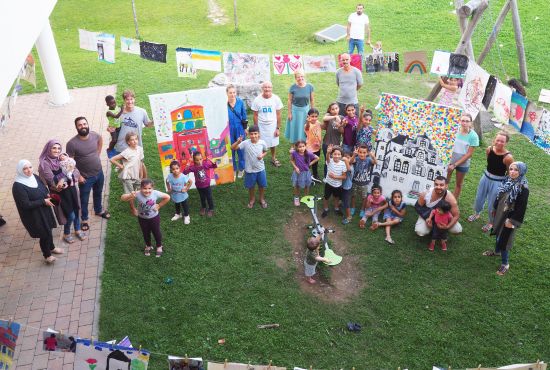 Kinder und erwachsene Menschen zeigen gemalte Bilder von Wangen