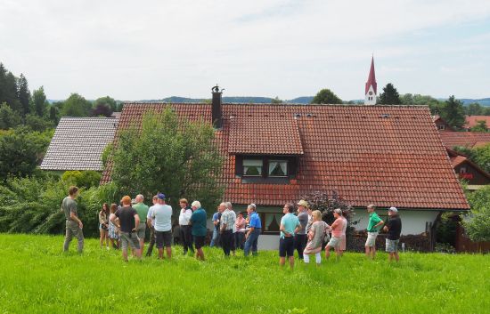 Menschen stehen auf einer Wiese bei Deuchelried