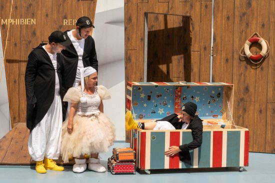 Vier Schauspieler, drei als Pinguine, einer als Taube verkleidet.