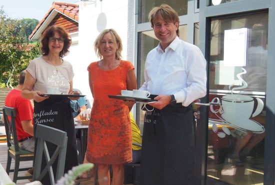 Zwei Frauen und ein Mann mit Tablett und Kaffeetassen.