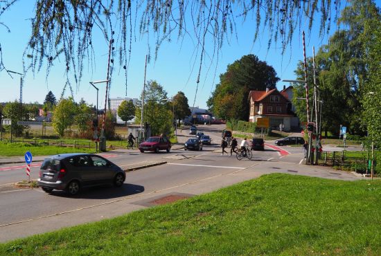 Autos und Fahrräder am Bahnübergang