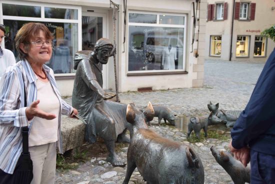 Eine Frau steht bei den Schweinen am Saumarkt