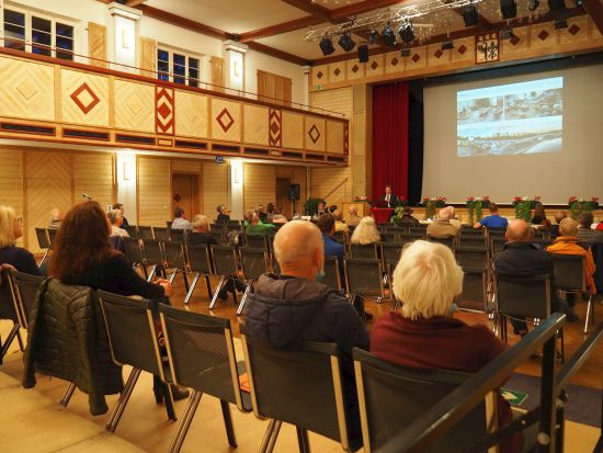 Menschen in der Stadthalle hören Vortrag 