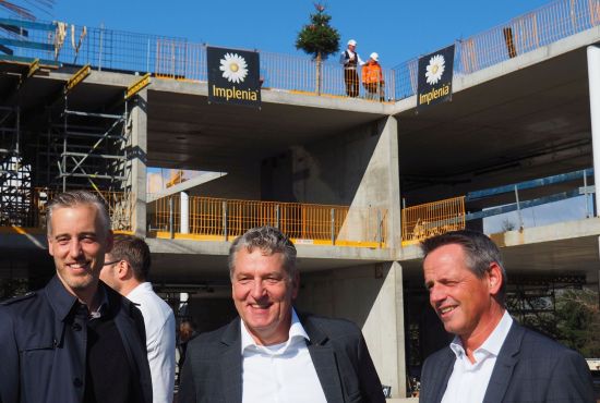 Drei Männer vor einer Baustelle