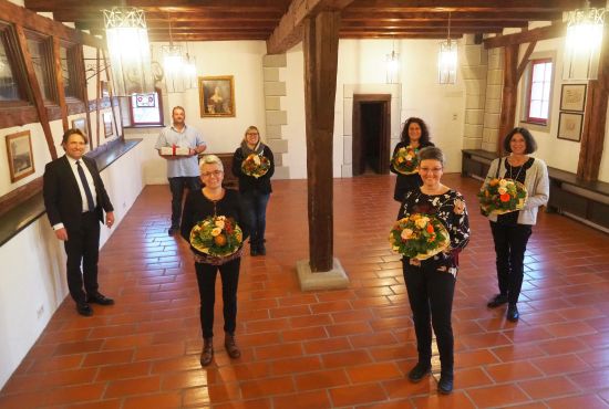 Frauen mit Blumen, zwei Männer