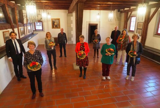 Frauen mit Blumen, drei Männer