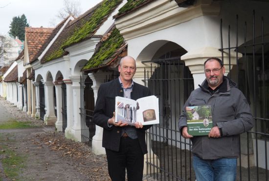 Zwei Männer zeigen ein Buch
