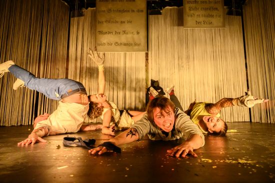 Drei Schauspieler liegen auf der Bühne