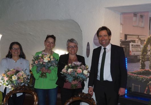 Oberbürgermeister Michael Lang und drei Frauen mit Blumen