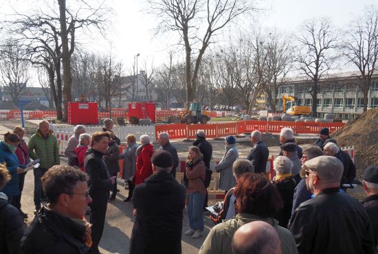 Menschen vor der Baustelle am Festplatz 