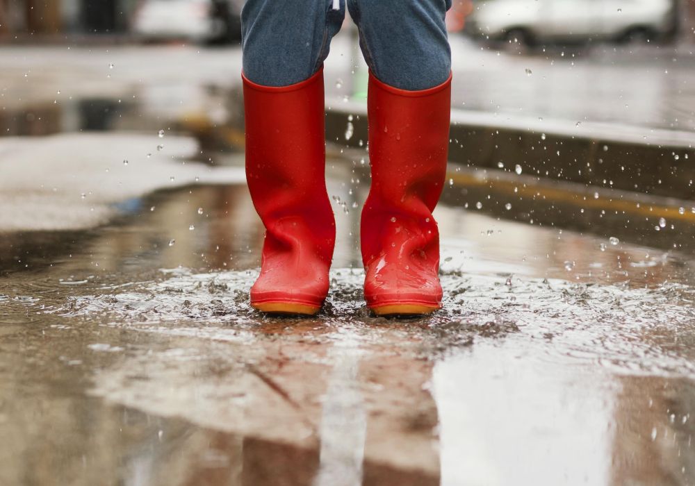 Rote Gummistiefel in großer Pfütze