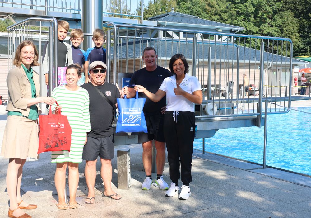 Mitarbeiter von Stadt und Freibad beschenken eine Familie.
