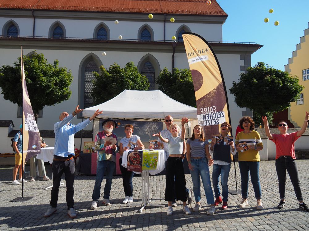 Menschen auf dem Marktplatz werfen Bälle