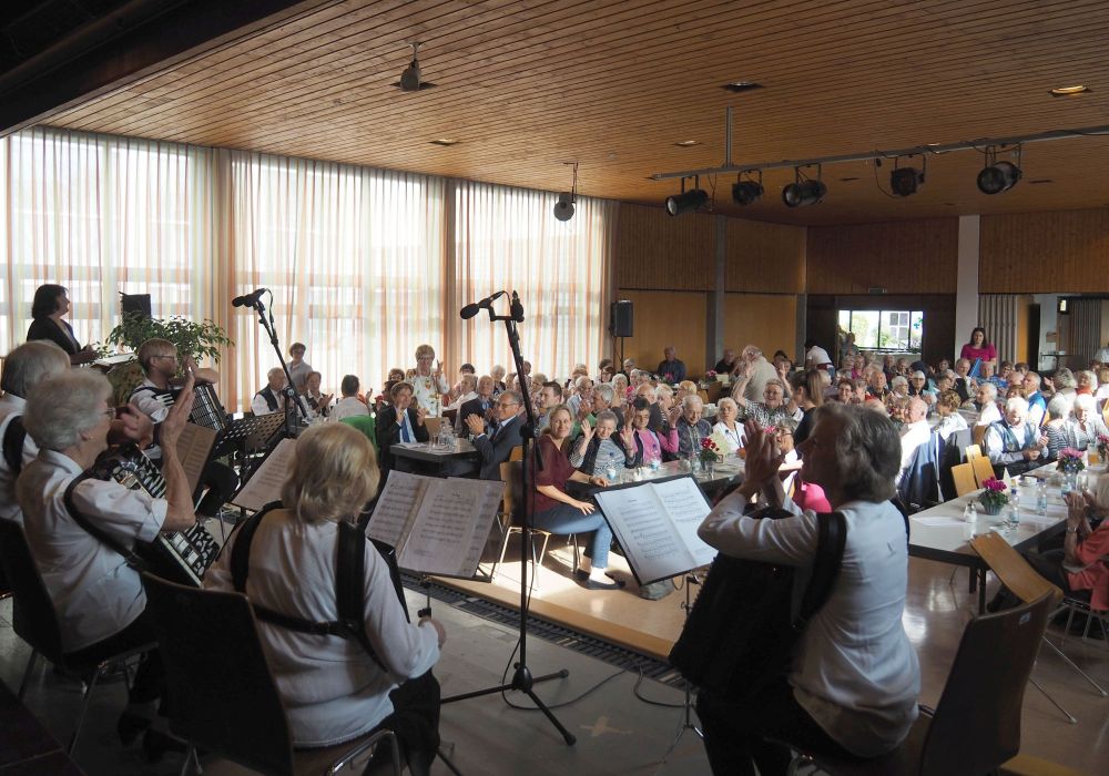 Menschen klatschen Beifall für Akkordeonorchester