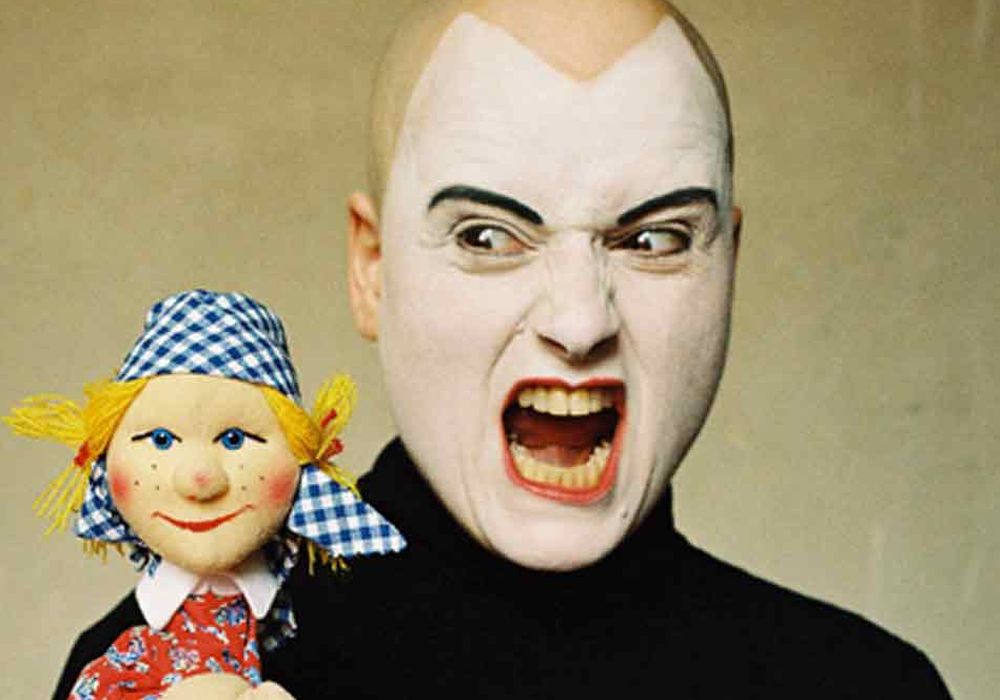 Schauspieler als Teufel verkleidet mit Puppe