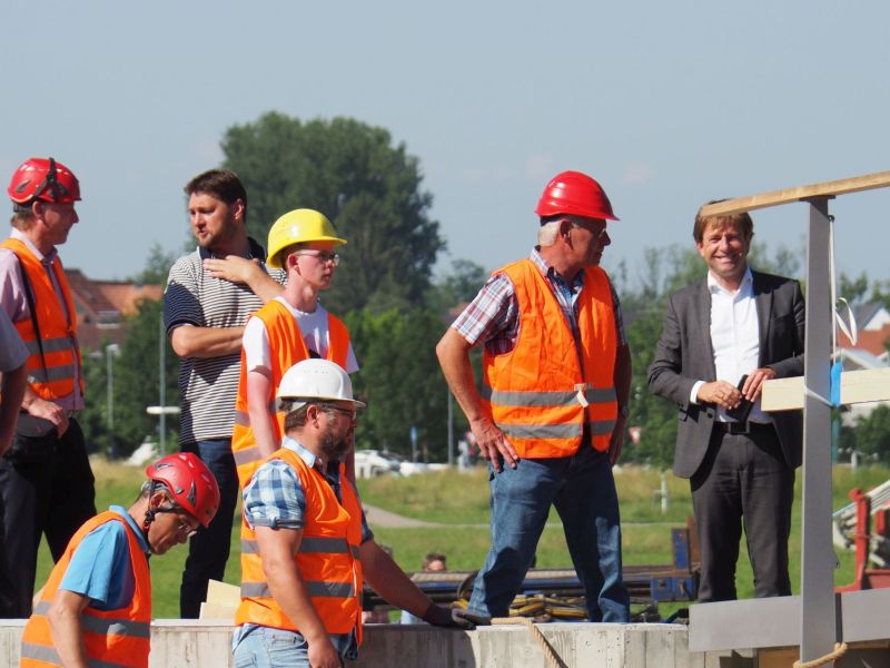 Oberbürgermeister Michael Lang mit Bauarbeitern und Bauleitern beim Bau einer neuen Fußgängerbrücke