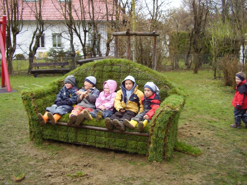 Fünf Kindergartenkinder sitzen auf einem Sofa aus Moos