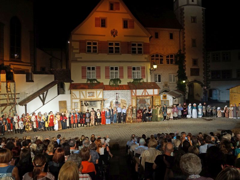 Freiluft-Theateraufführung vor historischer Kulisse auf dem Postplatz mit zahlreichen Darstellern und Zuschauern