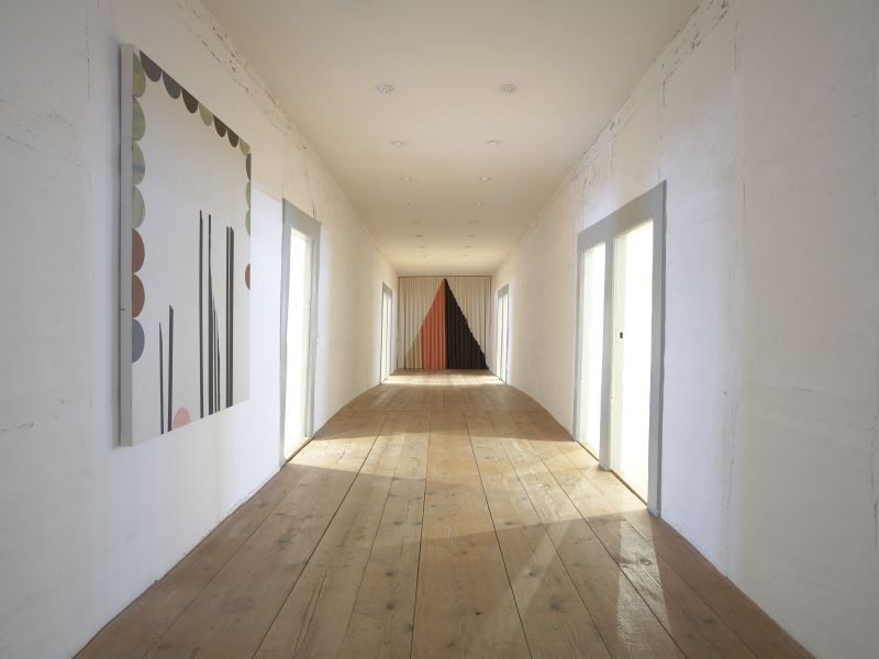 Galerie in der Badstube: ein langer heller Gang mit Gemälden an den Wänden