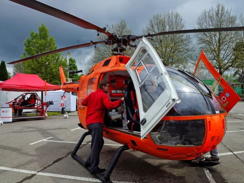 Ein Mann besichtigt einen Hubschrauber des Deutschen Roten Kreuzes