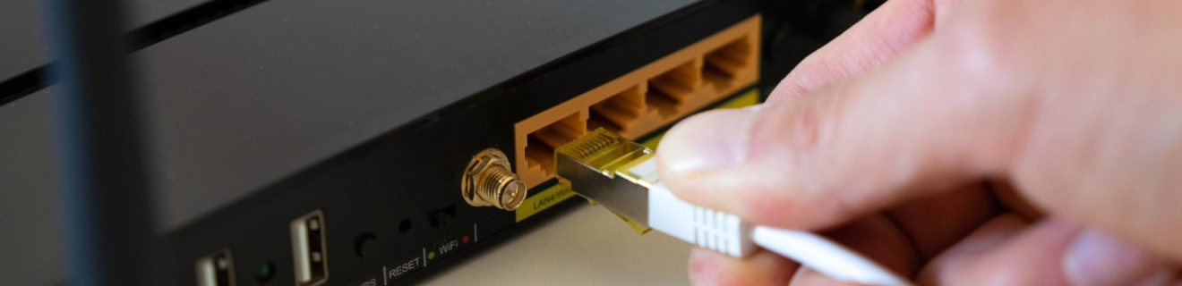 Eine Hand zieht einen Stecker aus einem Laptop.