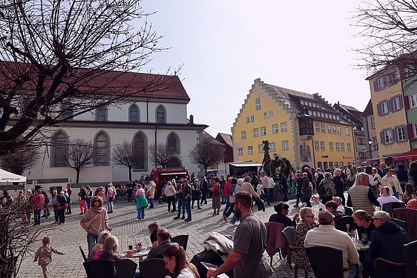 Viele Menschen auf dem Marktplatz in Cafes und vor dem Rathaus.