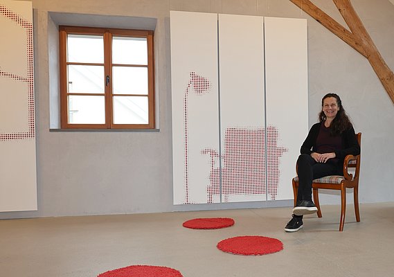 Eine Frau in einem Stuhl vor einem Bild mit einem Stuhl.