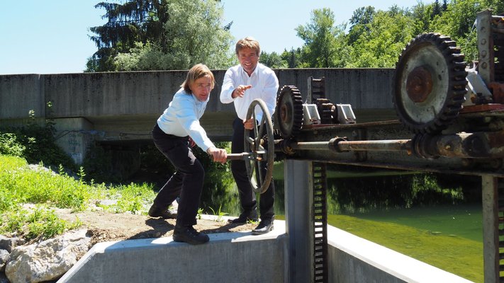 Oberbürgermeister Michael Lang und Stadtwerkeleiter Urs Geuppert öffnen den Ritter beim Wasserkraftwerk in Epplings