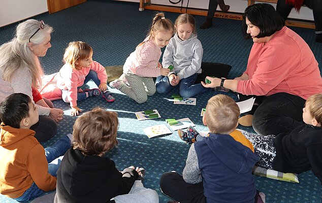 Kinder umringen zwei Erzieherinnen