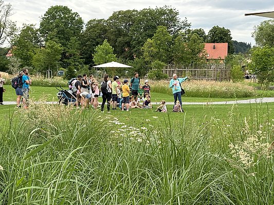 Erwachsene und Kinder im Park der Landesgartenschau bei einer Führung 