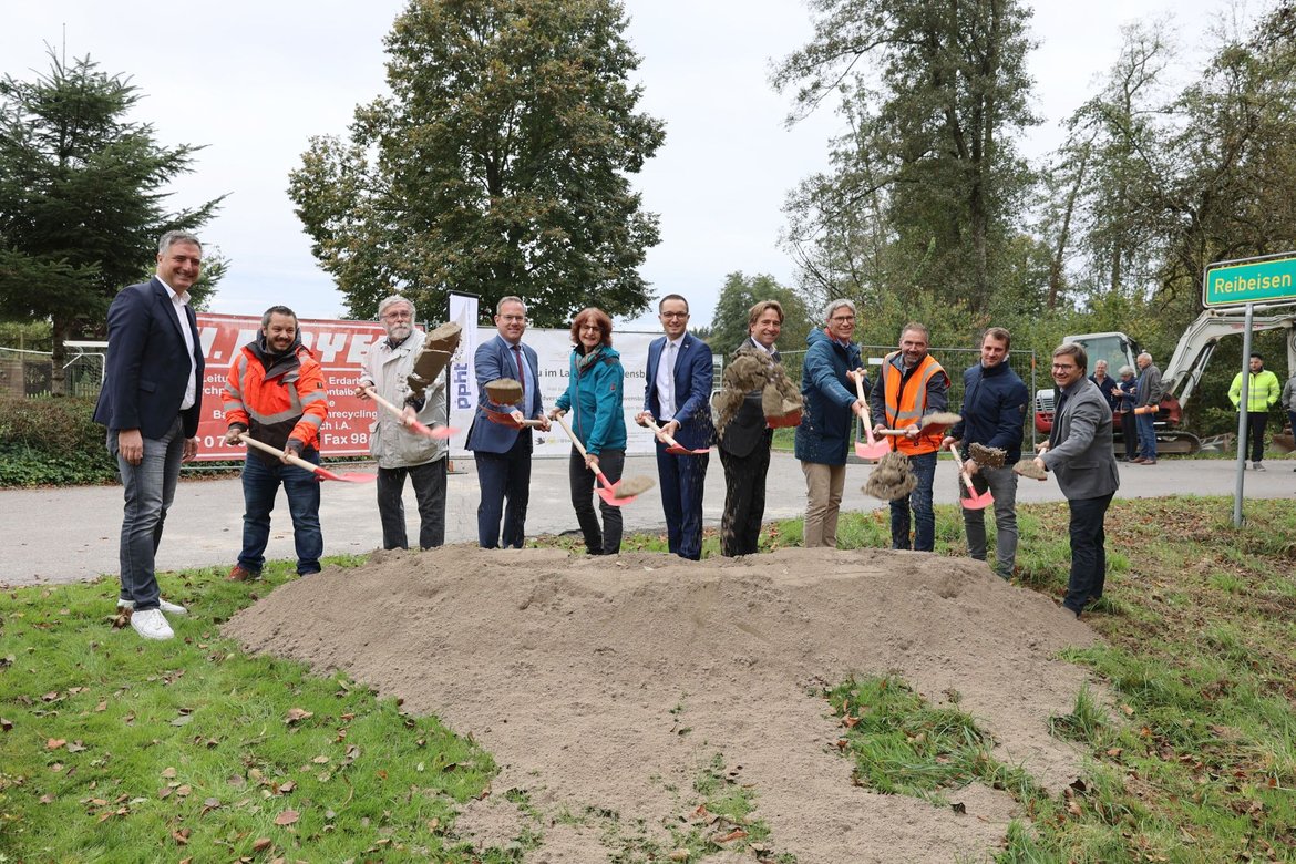 Elf Personen werfen mit Schaufeln Sand