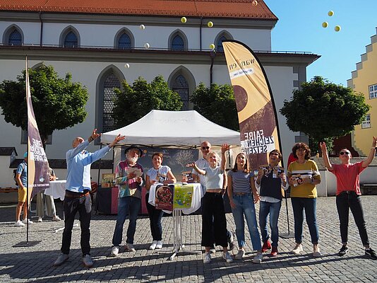 Menschen auf dem Marktplatz werfen Bälle