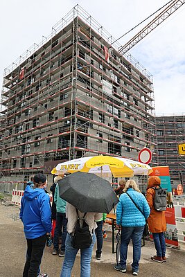 Menschen stehen vor einem der Punkthäuser in den Auwiesen