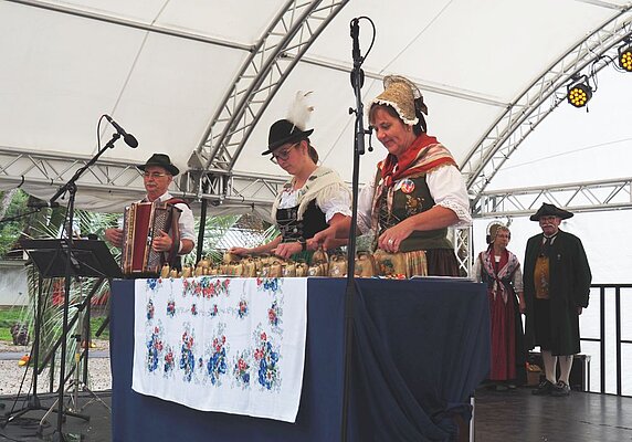 Zwei Frauen in Tracht spielen Glockenspiel.