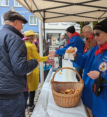 Menschen stehen für Most und Brezel an