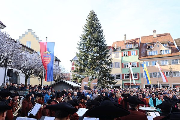Viele Menschen auf dem Marktplatz. Dazwischen die Flaggen von Fairtrade Stadt Wangen