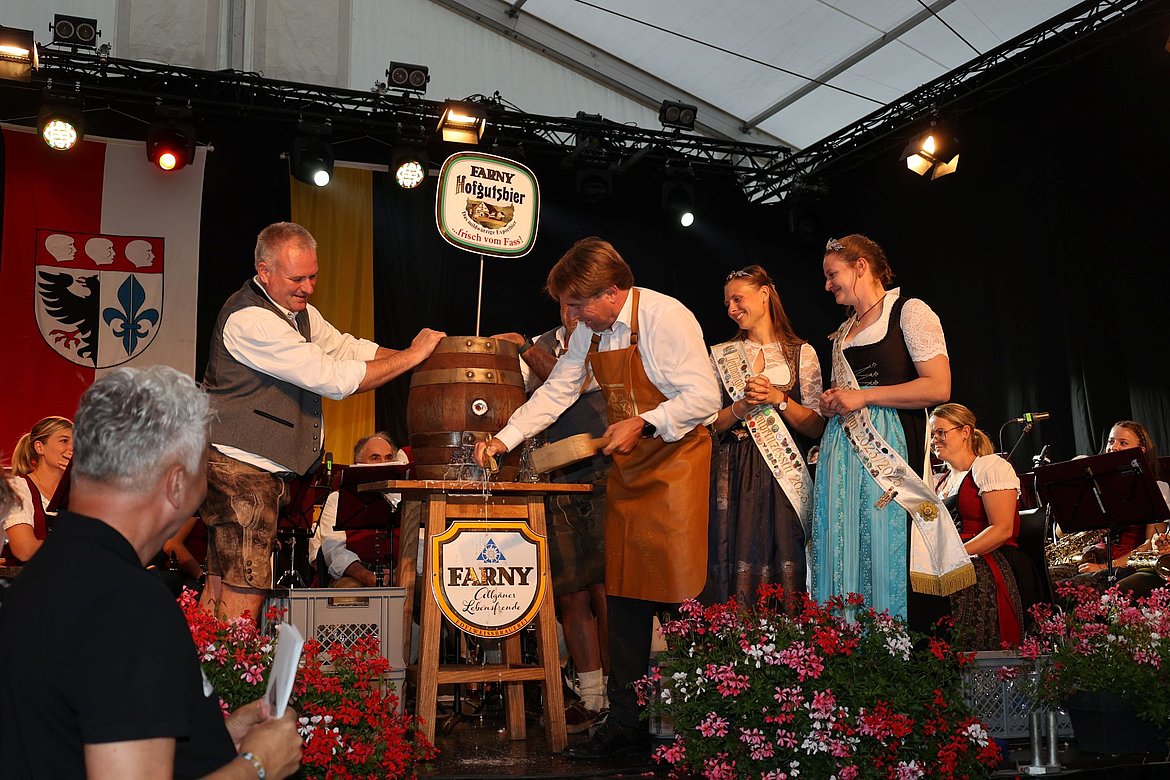 OB Michael Lang schlägt den Hahn ins Bierfass. Es spritzt ein bisschen.