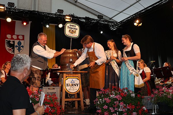 OB Michael Lang schlägt den Hahn ins Bierfass. Es spritzt ein bisschen.