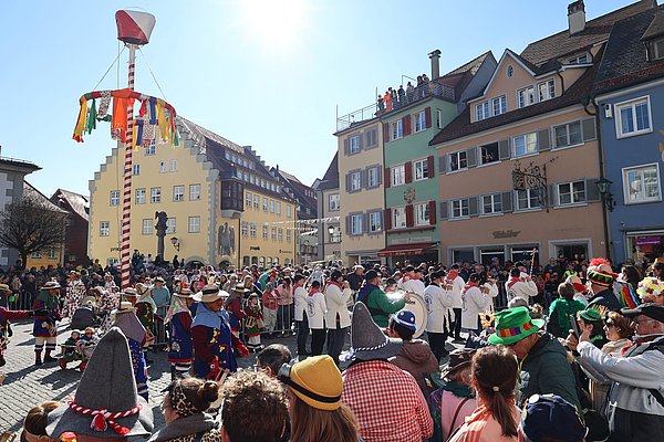 Viele Menschen am Marktplatz. In der Mitte der Narrenbaum.