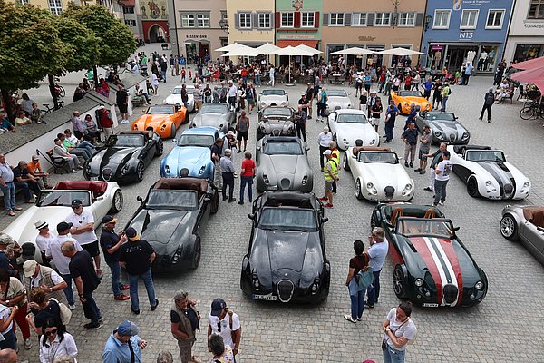 Sportwagen stehen in mehreren Reihen auf dem Marktplatz.