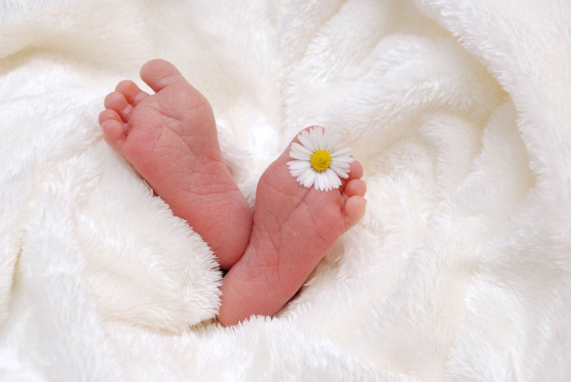 Babyfüße mit Blume