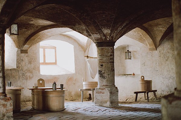 Badezuber aus Holz unter dem Kreuzgewölbe der Badstube.