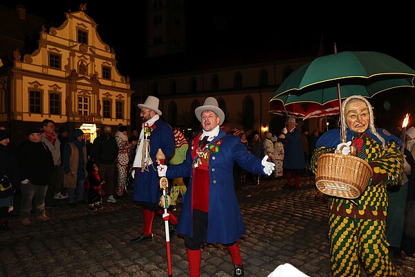 Zunftmeister und andere. Im Hintergrund das Rathaus
