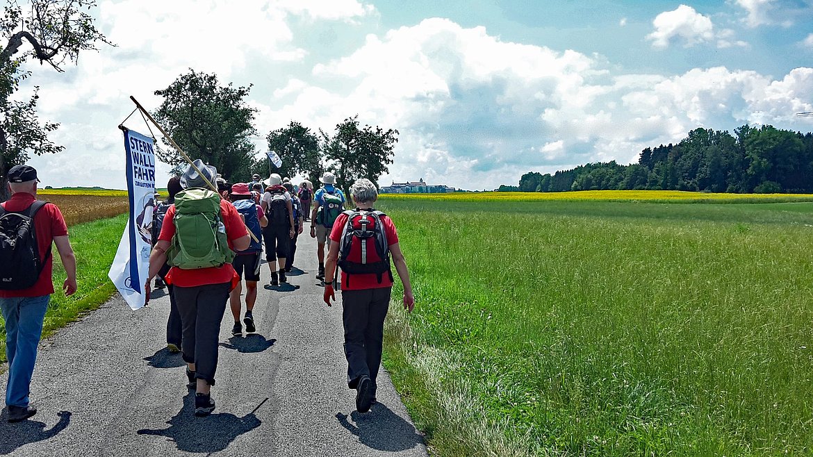 Pilgernde Menschen in der weiten Landschaft