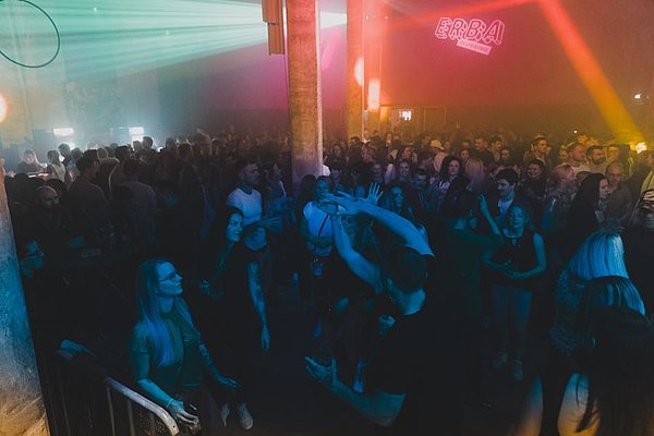 Viele Menschen feiern und tanzen in einem Club.