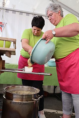Zwei Frauen bereiten Kässpätzle zu