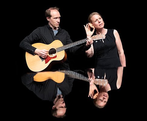 Ein Mann mit Gitarre und eine Frau. 