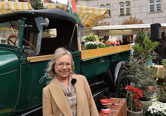 Frau vor grünem Blumen-Lastwagen